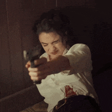 a woman in a white shirt is holding a torch in her hand