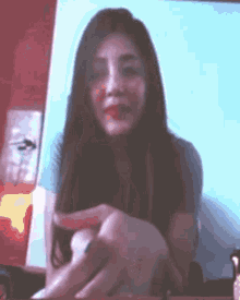 a woman with long hair is sitting in front of a screen