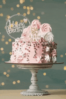 a pink birthday cake with a happy birthday sign on top of it