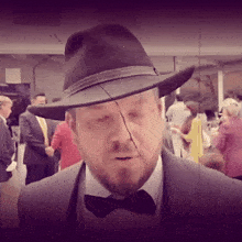 a man with a beard wearing a black hat and a bow tie
