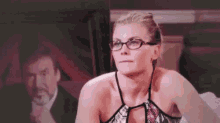 a woman wearing glasses is sitting in front of a man with a mustache .