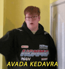 a man wearing a black hoodie with the words avada kedavra on it