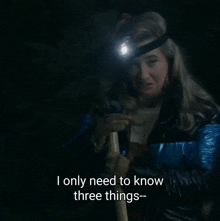 a woman wearing a headlamp is holding a stick and says i only need to know three things