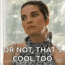 a woman is standing in front of a window and saying `` or not that 's cool too '' .