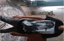 a man wearing a black shirt with a picture of tupac shakur
