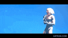 a woman singing into a microphone with gifrun.com in the corner