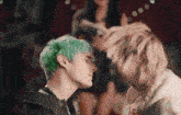 two men with green hair are standing next to each other .