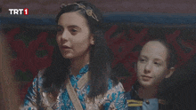 two girls sitting next to each other with trt1 written on the bottom