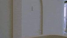 a woman in a white shirt is standing in a doorway with a sign on the wall that says ' a '
