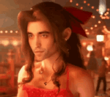 a man with long hair is wearing a red dress .