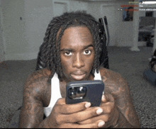 a man with dreadlocks is looking at his phone