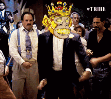 a man in a tuxedo with a monkey on his head and the word tribe on the bottom right
