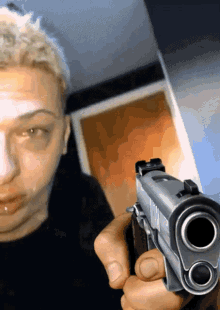 a man with a black eye is holding a gun in his hand