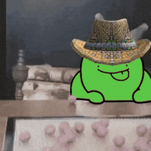 a green frog is wearing a cowboy hat