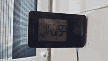 a meteo thermometer is hanging on a wall next to a window