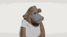 a stuffed monkey is wearing a white shirt and making a face