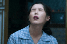 a woman in a blue plaid shirt with her mouth open