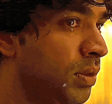 a close up of a man 's face with a tear running down his face