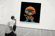 a man is looking at a painting of a boy with a pacifier and the word lotto on it