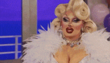a drag queen is wearing a white feather boa .