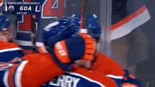 a hockey player named erry is hugging another hockey player