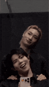 a man taking a picture of himself with another man behind him