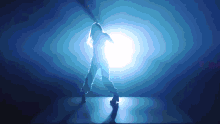 a silhouette of a woman is dancing in a dark room