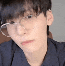 a close up of a person wearing glasses and making a face .