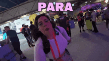a woman blowing a kiss in a crowded room with the word para above her
