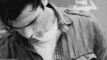 a black and white photo of a young man in a denim jacket .