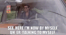 a man is sitting in the driver 's seat of a car and talking to myself .