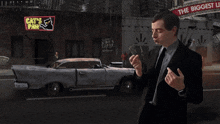 a man in a suit stands in front of a cat 's paw sign