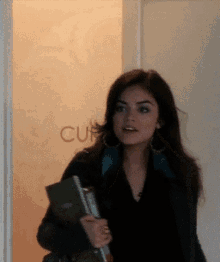 a woman standing in front of a door that has the word cuf on it