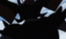 a silhouette of a bat with wings flying in the sky
