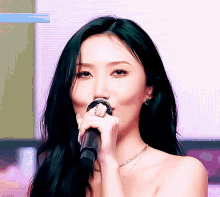a close up of a woman singing into a microphone with a sticker that says ' sbs ' on it