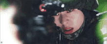 a close up of a woman wearing a military helmet and looking at the camera .