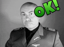 a man in a military uniform is making a funny face with the word ok above him