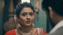 a woman in a red dress is looking at a man .