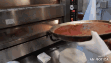 a pizza being taken out of an oven with the words made in animotica visible