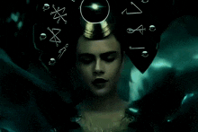 a woman with a crown on her head is surrounded by symbols and letters