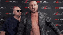 two men standing in front of a wall that says betonline