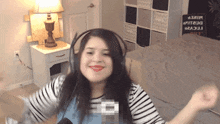 a woman wearing headphones is dancing in front of a sign that says " i love "
