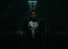 a man in a punisher costume is holding two guns in a dark tunnel