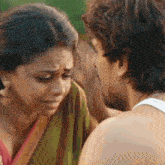 a man kisses a woman on the cheek while she cries