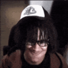 a man wearing glasses and a white hat with the letter l on it
