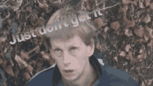 a man stands in front of a bush with the words just do n't get it on his head