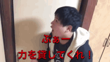 a man standing in front of a door with chinese writing on it .