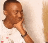 a man is sitting down with his hand on his chin and looking at something .