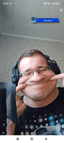a man wearing headphones is making a funny face with his hands