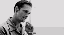 a black and white photo of a man giving a thumbs up and saying `` fuck you '' .